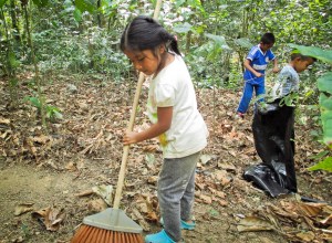 niña barriendo el bosque