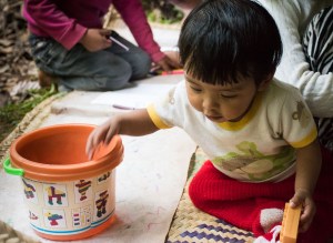 bebé jugando con cubos sobre petate