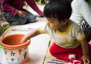 bebé jugando con cubos sobre petate