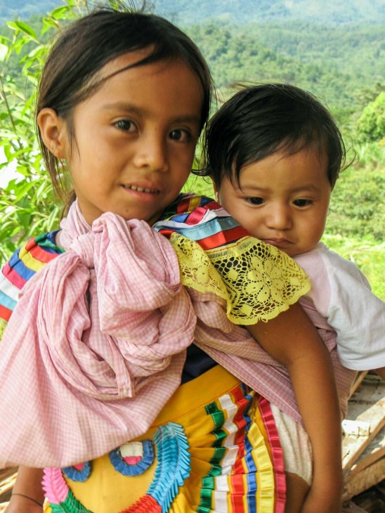 NIÑA CARGANDO BEBÉ