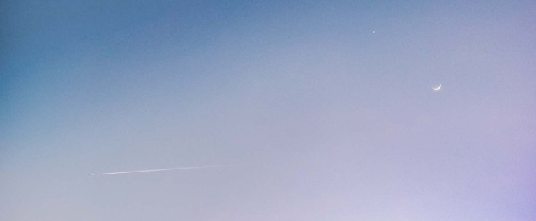 avión con estela atardecer